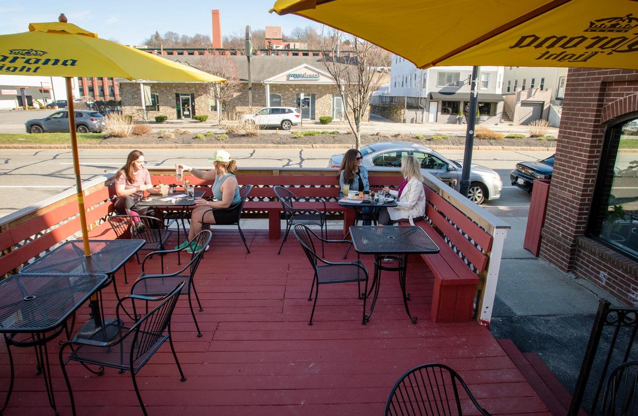 Diners sit at outdoor tables on the deck at Flying Rhino on Shrewsbury Street Tuesday.