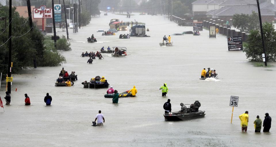 people use boats to navigate flooded streets during hurricane harvey