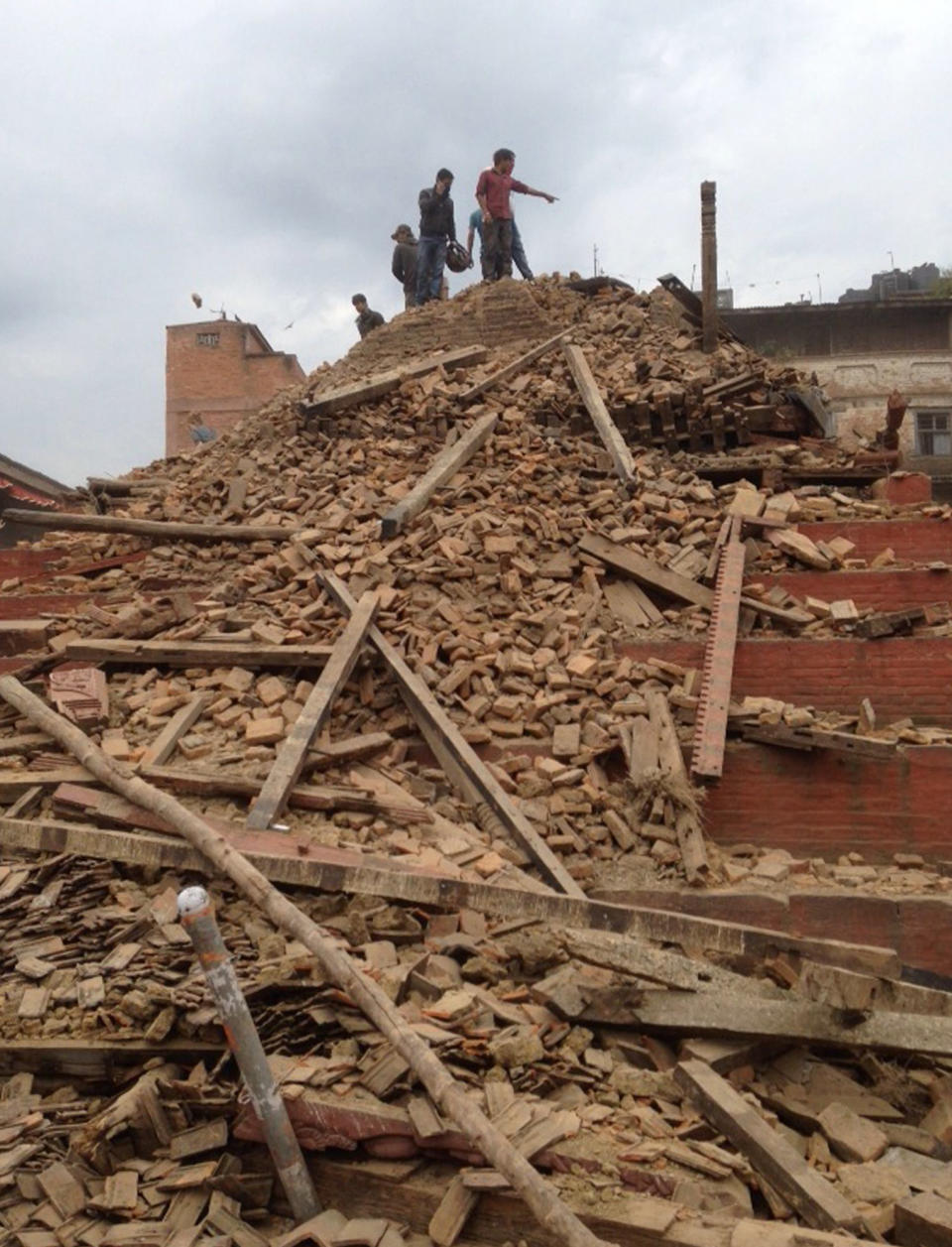 Volunteers help with rescue work at the site of a building that collapsed, April 25, 2015. (AP Photo/ Niranjan Shrestha)