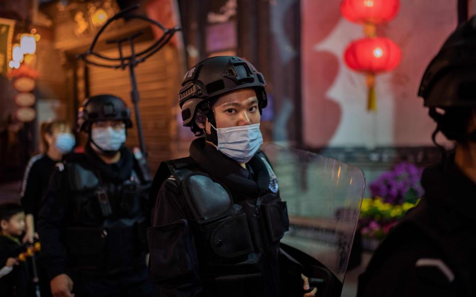 Security guards patrol on a street outside of a shopping mall complex in Beijing  - NICOLAS ASFOURI , AFP