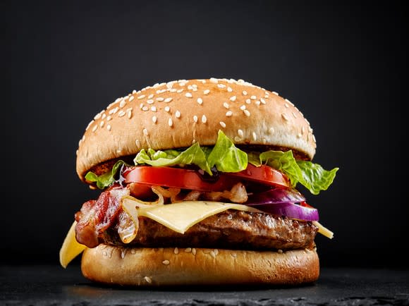 Bacon cheeseburger on a black background.