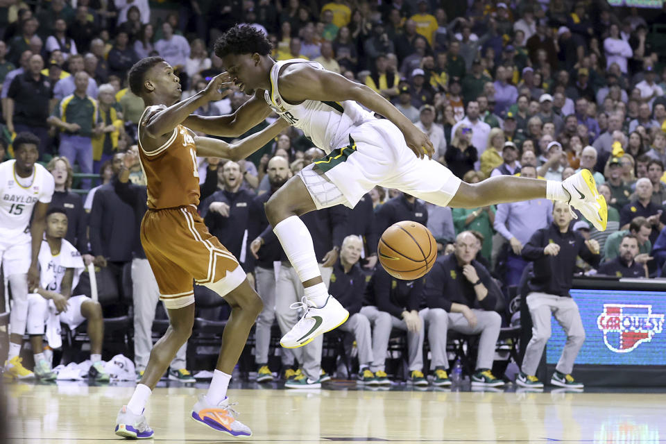 Baylor guard Adam Flagler (10) is fouled by Texas guard Sir'Jabari Rice (10) as he attempts to score during the second half of an NCAA college basketball game Saturday, Feb. 25, 2023, in Waco, Texas. (AP Photo/Jerry Larson)