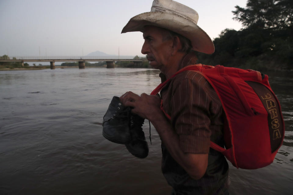 A Central American migrant crosses the Suchiate River from Tecun Uman, Guatemala, to Mexico, Thursday, Jan. 23, 2020. Migrants hoping to reach the United States marooned in Guatemala waded en masse across a river leading to Mexico in an attempt to convince authorities there to allow them passage through the country. (AP Photo/Moises Castillo)