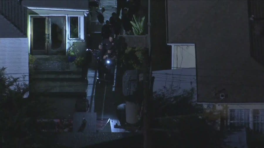 Officers investigating a home invasion in L.A. seen approaching the back of a residence with their guns drawn on July 17, 2024. (Sky5)