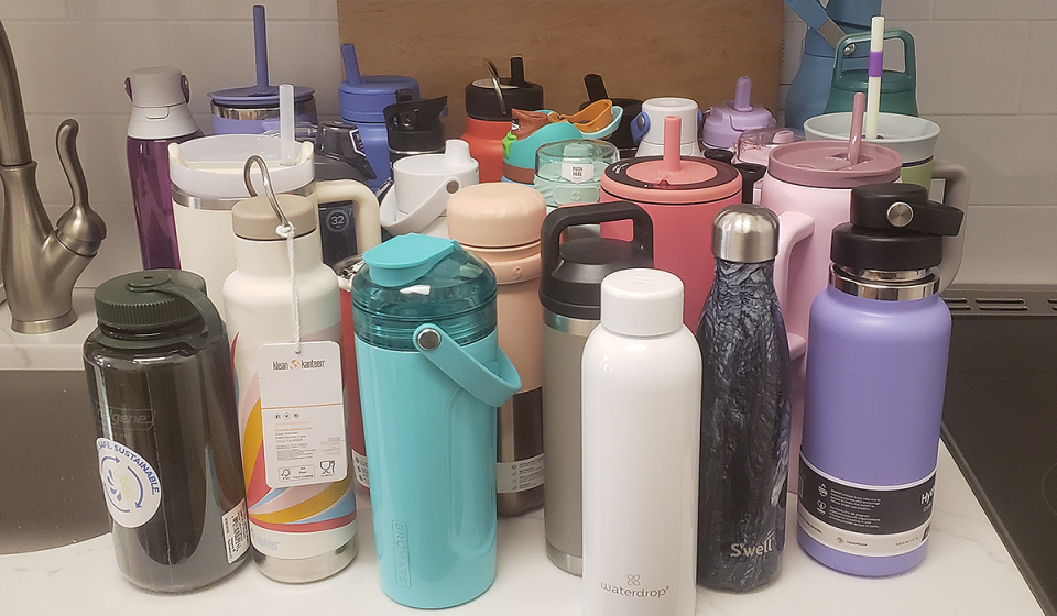 More than 20 water bottles are shown grouped together on a counter, to be tested for Yahoo's best water bottle guide