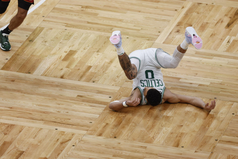 Boston Celtics forward Jayson Tatum (0) falls to the court in the first half of Game 1 of the NBA basketball Eastern Conference finals playoff series against the Miami Heat in Boston, Wednesday, May 17, 2023. (AP Photo/Michael Dwyer)