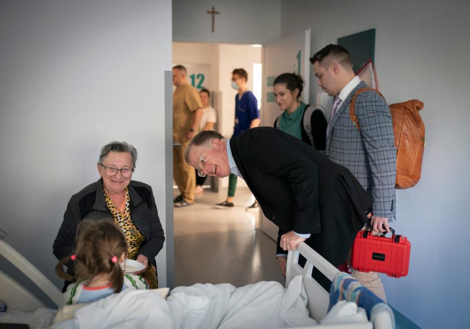 Valentina Ukhvatova, 75, of Dnipro smiles as Dr. David Brown, a plastic surgeon from the University of Michigan makes morning rounds on Tuesday, May 16, 2023 to check on her great granddaughter Evheniia Ukhvatova, 6, while she recovers from surgery she had the day before in Leczna, Poland. Evheniia Ukhvatova had surgery on burn scars that cover the backs of her legs and feet due to the contractures of old scar tissue.