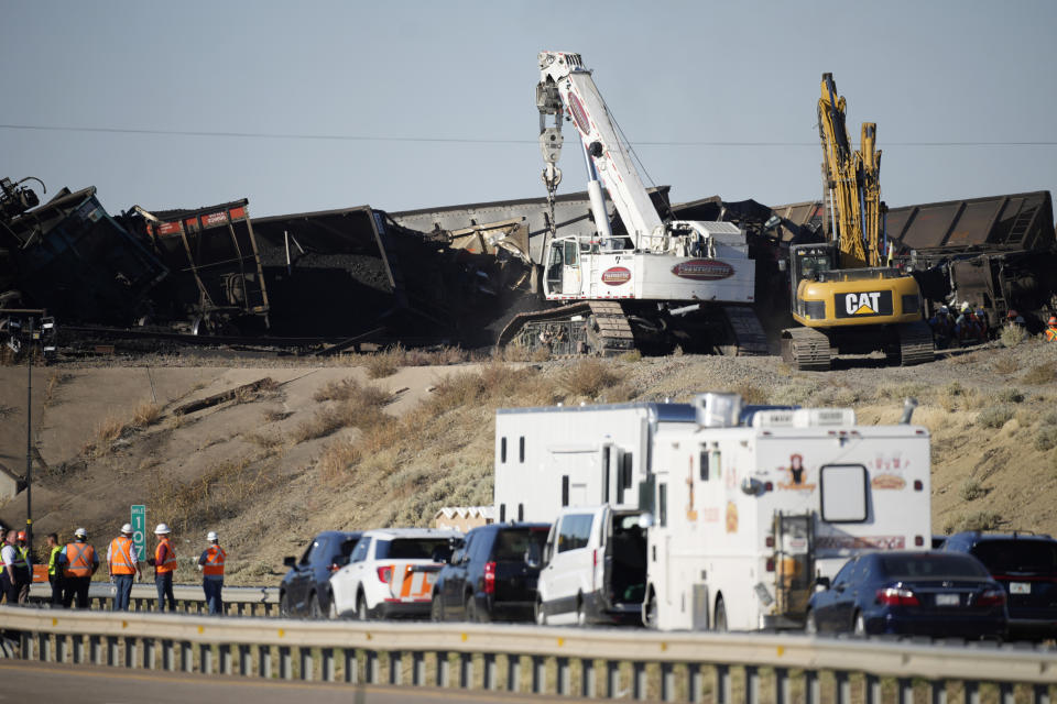 Workers toil to clear cars that derailed in an accident over Interstate 25 northbound, Monday, Oct. 16, 2023, north of Pueblo, Colo. (AP Photo/David Zalubowski)