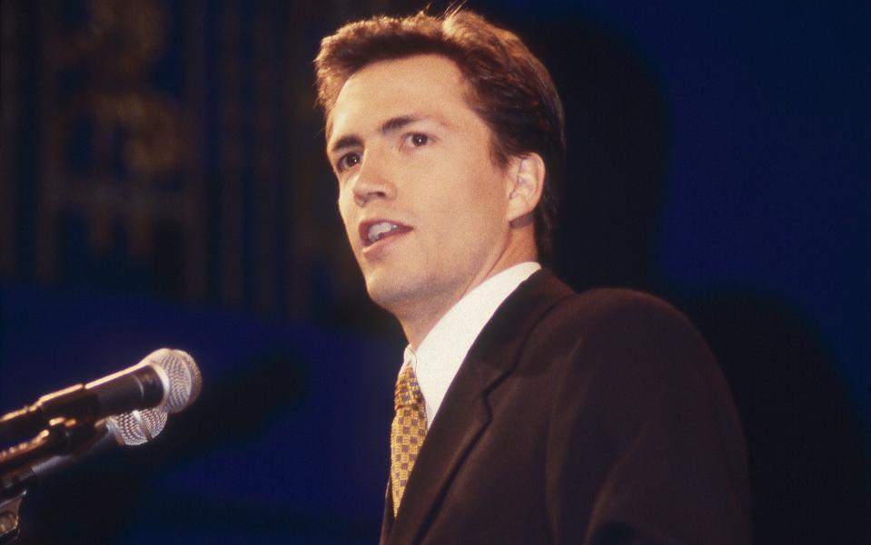 Andrew Shue speaking at a public event dressed in formal clothes