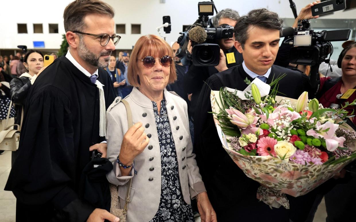 Gisèle Pélicot flanked by her lawyers with flowers from members of the public