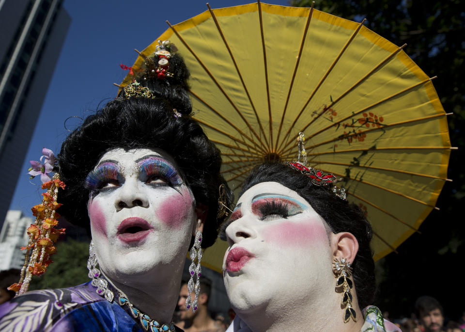 Revelers pose for photos during the annual Gay Pride Parade in Sao Paulo, Brazil, Sunday, May 4, 2014. Gay rights advocates are calling for a Brazilian law against discrimination as they gather by the hundreds of thousands in Sao Paulo for one of the world's largest gay pride parades. (AP Photo/Andre Penner)