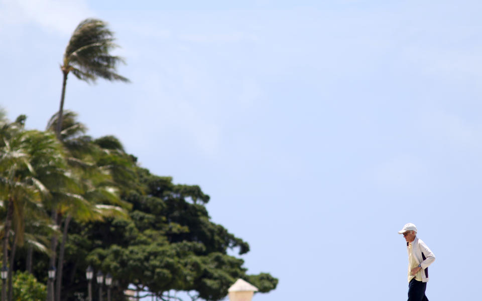 A man walks on a closed pier on Waikiki Beach in Honolulu on Saturday, March 28, 2020. Like many cities across the world, Honolulu came to an eerie standstill this weekend as the coronavirus pandemic spread throughout the islands. But Hawaii officials went beyond the standard stay-at-home orders and effectively flipped the switch on the state's tourism-fueled economic engine in a bid to slow the spread of the virus. As of Thursday, anyone arriving in Hawaii must undergo a mandatory 14-day self-quarantine. The unprecedented move dramatically reduced the number of people on beaches, in city parks and on country roads where many people rely on tourism to pay for the high cost of living in Hawaii. (AP Photo/Caleb Jones)