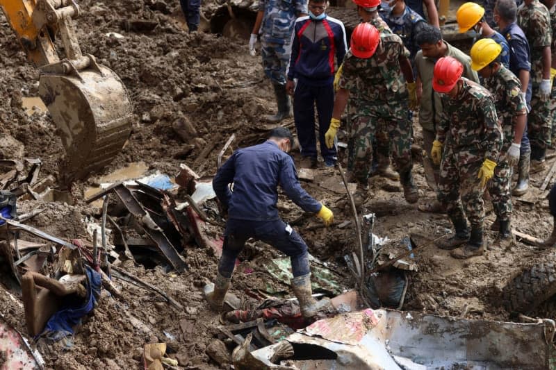 Search and rescue teams look for survivors and bodies at a landslide site following heavy rainfall and floods in Dhading District. Aryan Dhimal/ZUMA Press Wire/dpa