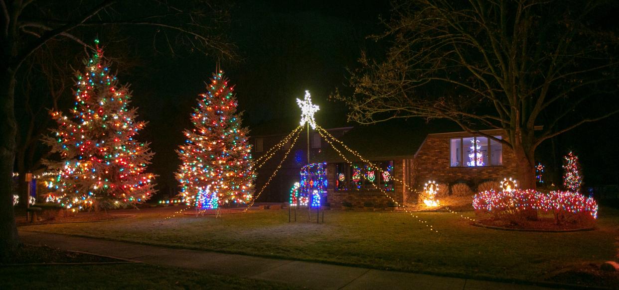 Christmas lights and trees dominate a yard, Tuesday, December 14, 2021, in Kohler, Wis.