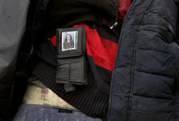 A wallet containing a photo of a young girl lies on top of a corpse in Bucha on April 6. 