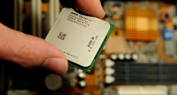 Hand putting cpu processor Advanced Micro Devices AMD Opteron chip in motherboard