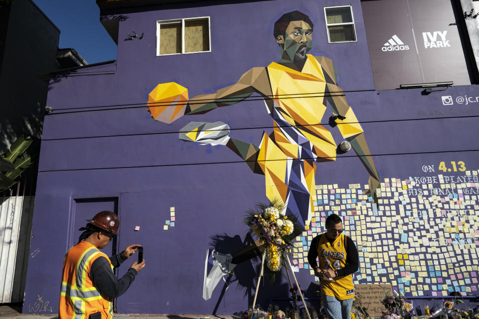 People gather in front of a mural in honour of former NBA star Kobe Bryant in Los Angeles, California. (Credit: Ronen Tivony / Echoes Wire/Barcroft Media via Getty Images)