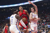 Toronto Raptors' Scottie Barnes drives between Oklahoma City Thunder's Luguentz Dort, left, and Josh Giddey during the first half of an NBA basketball game Wednesday, Dec. 8, 2021, in Toronto. (Chris Young/The Canadian Press via AP)