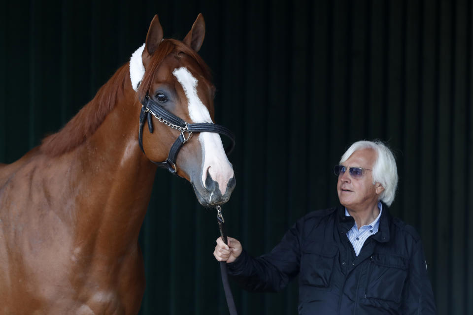 Trainer Bob Baffert walks Kentucky Derby winner Justify through a barn before the Preakness Stakes. (USAT)