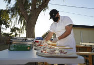 Chef Jose Hernandez preps several pizzas at his makeshift backyard pizza kitchen in Scottsdale, Ariz. on April 3, 2021. Hernandez and his wife Ruby Salgado spend their weekends making pizzas in a backyard oven they built. Some nights, they churn out as many as 30 pies with toppings like fennel sausage, fresh mozzarella and carne asada. (AP Photo/Ross D. Franklin)