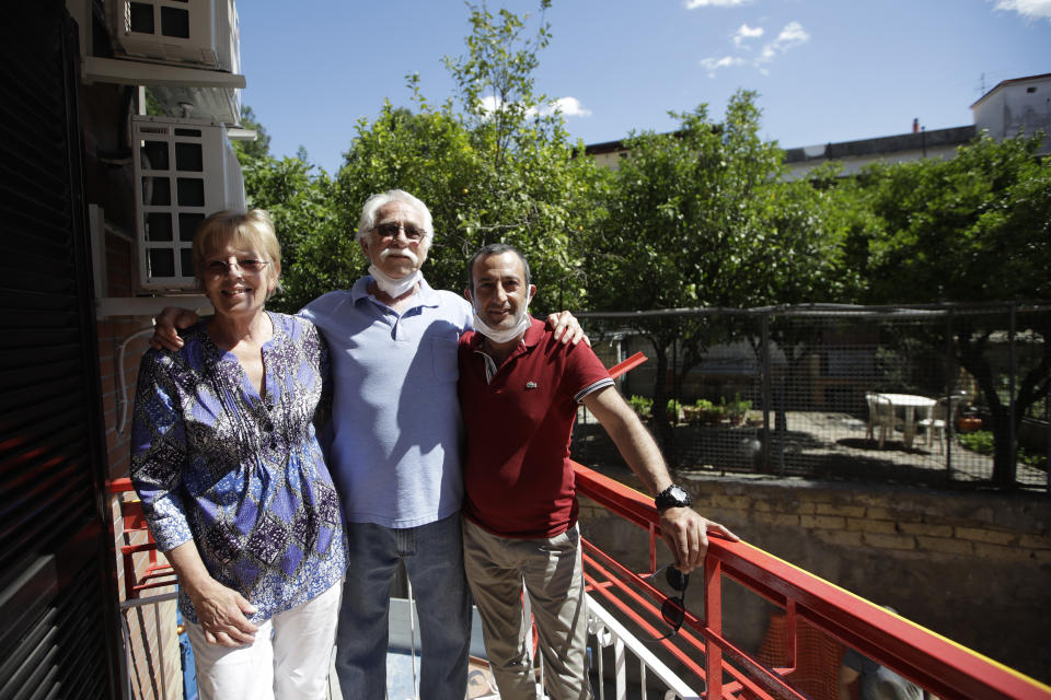 Marvin, center, and Colleen Hewson, left, from the United States, pose for a photograph with Fabio Sposato, the owner of the apartment where they stayed, on a balcony overlooking lemon trees, in Pompeii, near Naples, southern Italy, Tuesday, May 26, 2020. An American couple waited a lifetime plus 2 ½ months to visit the ancient ruins of Pompeii together. For Colleen and Marvin Hewson, the visit to the ruins of an ancient city destroyed in A.D. 79 by a volcanic eruption was meant to be the highlight a trip to celebrate his 75th birthday and their 30th anniversary. They were among the only tourists present when the archaeological site reopened to the public on Tuesday after the national lockdown to prevent the spread of COVID-19. (AP Photo/Alessandra Tarantino)