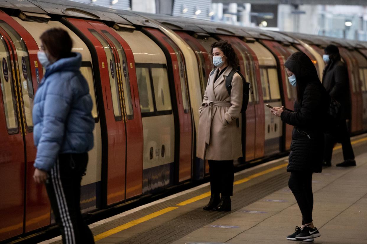 Commuters at Canning Town station in London (PA)