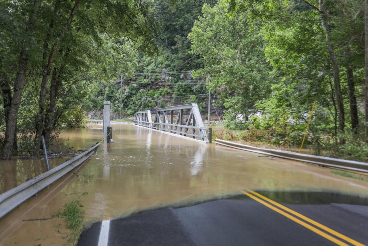 A bridge and road submerged by floodwaters from the North Fork of the Kentucky River in Jackson, Kentucky, July 28, 2022. <a href="https://www.gettyimages.com/detail/news-photo/bridge-and-a-road-are-submerged-by-floodwaters-from-the-news-photo/1242169925" rel="nofollow noopener" target="_blank" data-ylk="slk:Leandro Lozada/AFP via Getty Images;elm:context_link;itc:0;sec:content-canvas" class="link ">Leandro Lozada/AFP via Getty Images</a>