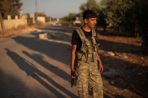 A Syrian rebel mans a checkpoint at the entrance to the town of Azaz, north of Aleppo, on August 11. The battle for Syria is raging on the ground but also on social media, where people on both sides of the conflict are hacking, posting and spamming in a frenzied propaganda war