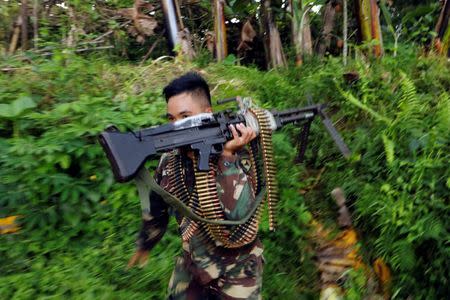 A Philippines army soldier runs with a machine gun in Marawi city, Philippines June 28, 2017. REUTERS/Jorge Silva