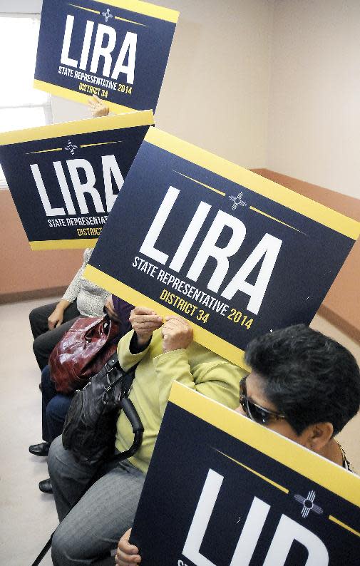 Christian Lira supporters hold up signs while covering their faces on Friday, March 7, 2014, at Sunland Park City Hall. All of sign holders wished to remain anonymous. (AP Photo/Las Cruces Sun-News, Robin Zielinski)