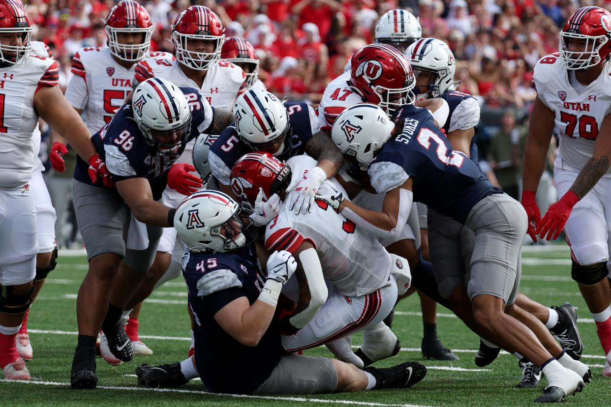 Utah Utes running back Ja'Quinden Jackson (3) is tackled by Arizona Wildcats defensive lineman Bill Norton (45) and linebacker Jacob Manu (5) during the first half at Arizona Stadium Nov. 18, 2023, in Tucson, Arizona.