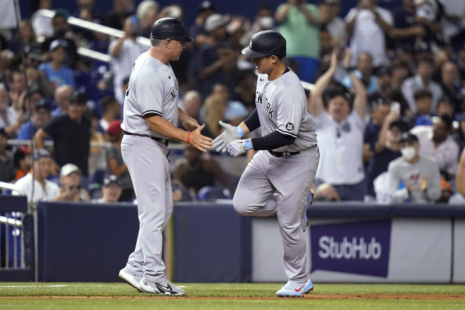 New York Yankees' Anthony Rizzo, right, is met by third base coach Phil Nevin after hitting a solo home run during the sixth inning of the team's baseball game against the Miami Marlins, Friday, July 30, 2021, in Miami. (AP Photo/Lynne Sladky)