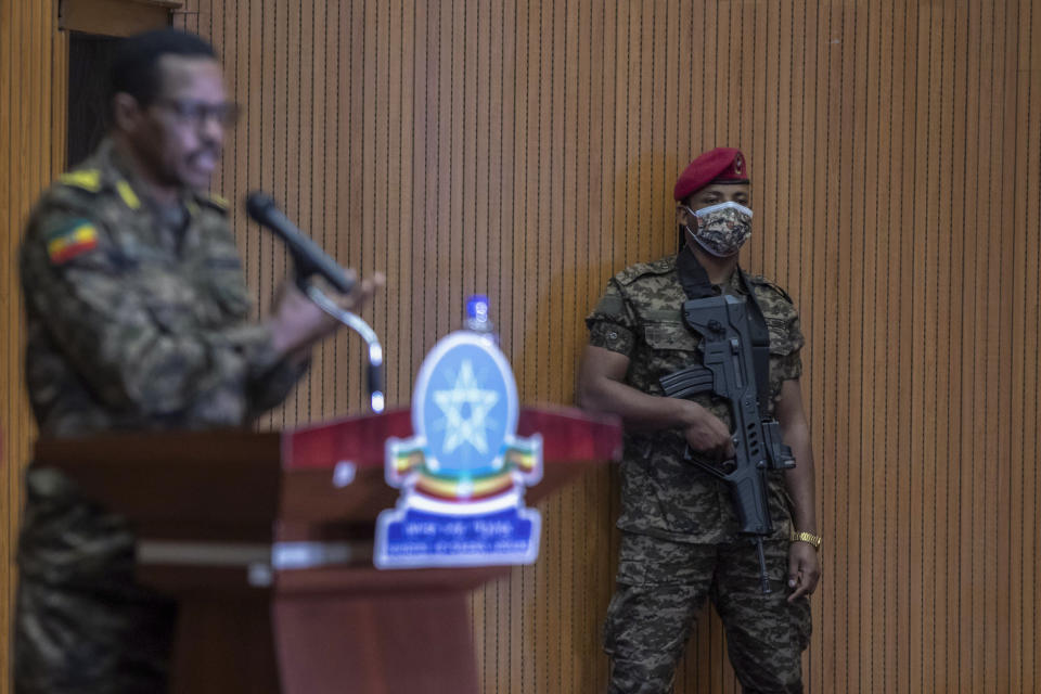 A member of the military stands guard as Lieutenant-General Bacha Debele of the Ethiopian National Defense Force, left, gives a joint press conference with State Minister of Foreign Affairs and Spokesperson for the State of Emergency Taskforce Redwan Hussein about the current situation in the country's northern Tigray region, in the capital Addis Ababa, Ethiopia Wednesday, June 30, 2021. (AP Photo/Mulugeta Ayene)