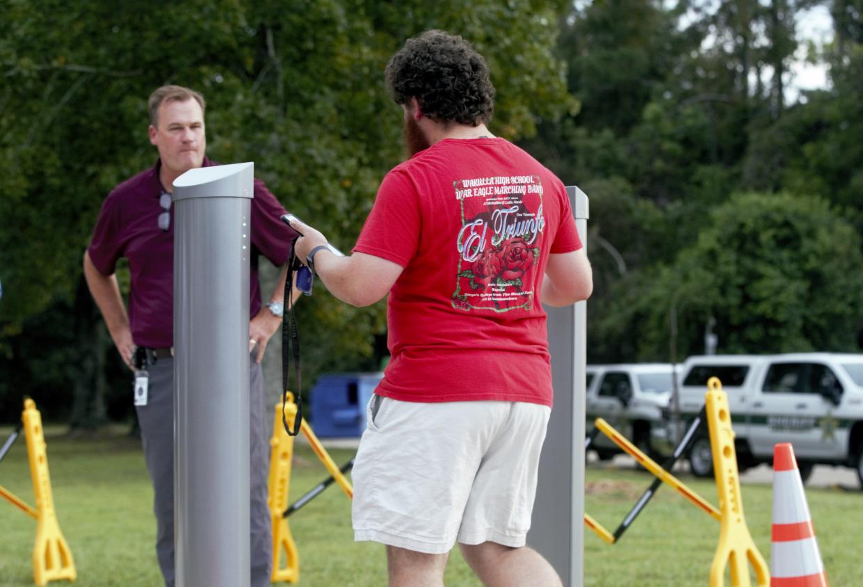 A man walks through the new security system donated to Leon County Schools at Gene Cox Stadium.