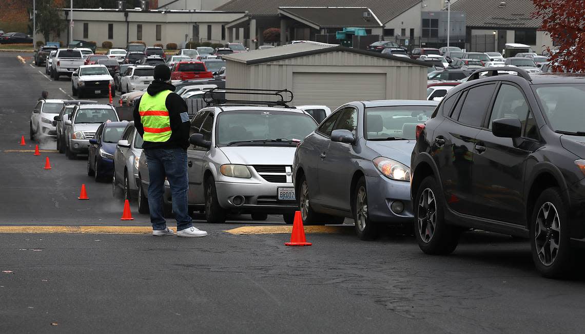 A volunteer helps line up vehicles in the parking lot of the LifeChurch7 in Richland Friday morning for the 2nd Harvest Mobile Market event. About 50 volunteers from the church and Energy Northwest were on hand to help give out free food for about 250 Mid-Columbia families. Bob Brawdy/bbrawdy@tricityherald.com