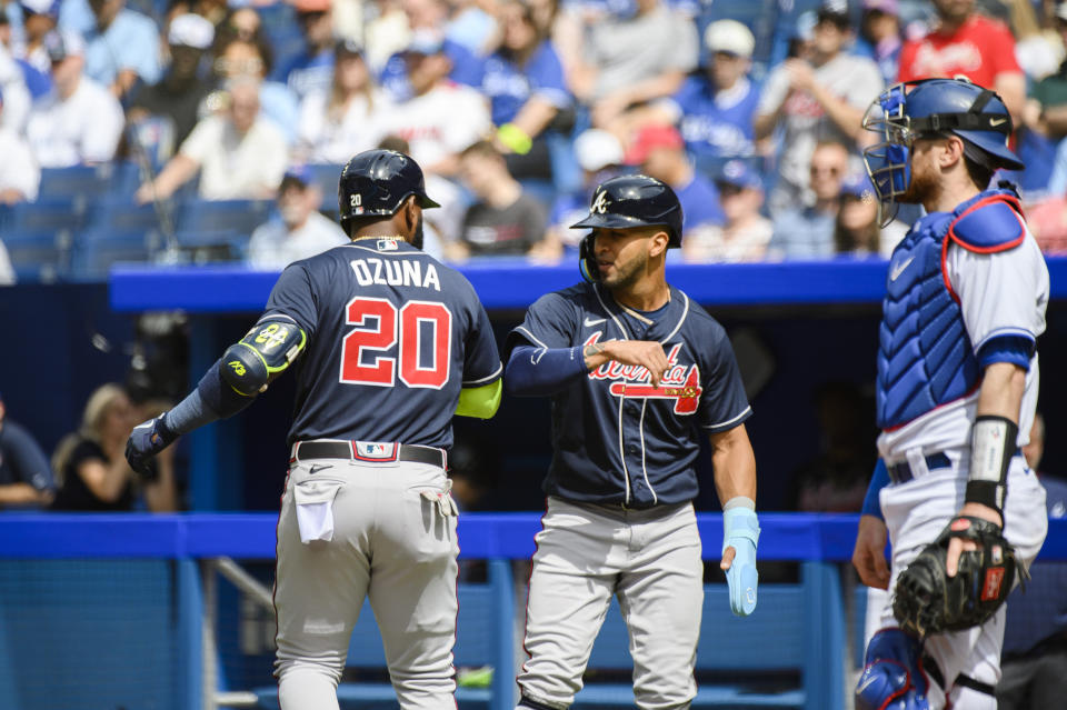 Atlanta Braves' Marcell Ozuna (20) and Eddie Rosario (8) celebrate after Ozuna (20) hit a two-run home run in the second inning of a baseball game against the Toronto Blue Jays, Saturday, May 13, 2023, in Toronto. (Christopher Katsarov/The Canadian Press via AP)