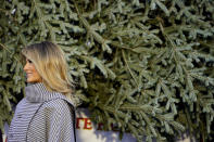 First lady Melania Trump stands next to the 2020 Official White House Christmas tree as it is presented on the North Portico of the White House, Monday, Nov. 23, 2020, in Washington. (AP Photo/Andrew Harnik)