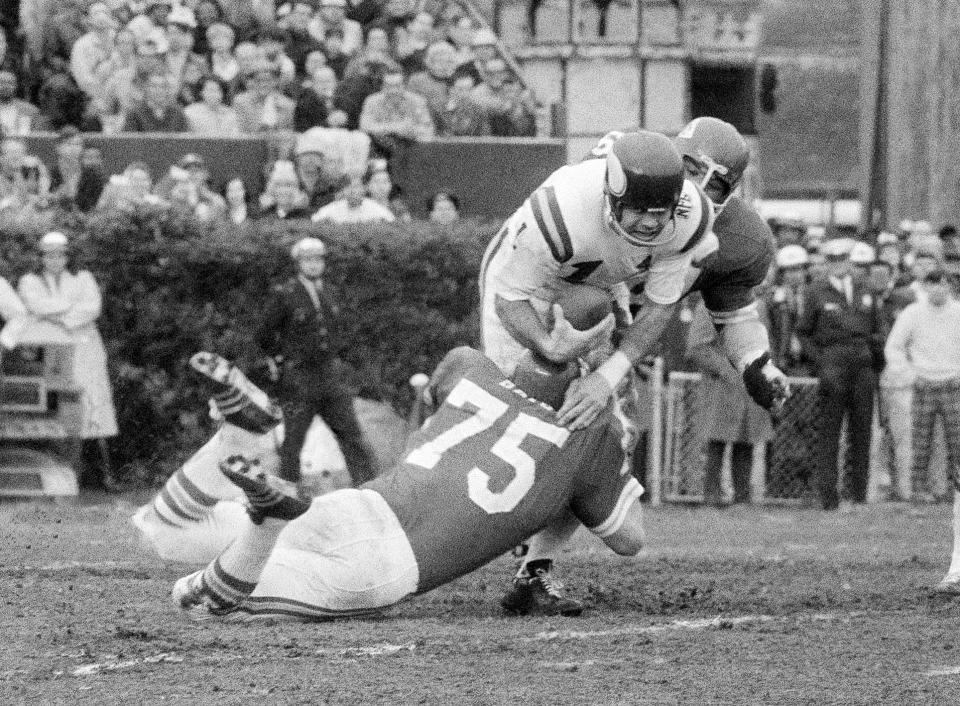 FILE - Minnesota Vikings quarterback Joe Kapp is hauled down by Kansas City Chiefs' Jerry Mays (75) as another Chiefs player moves in from the rear during the first half of the Super Bowl IV football game in New Orleans, Jan. 11, 1970. Kapp, the tough quarterback who led the Minnesota Vikings to their first Super Bowl and California to its last Rose Bowl, has died. He was 85. Cal confirmed that Kapp died on Monday, May 8, 2023. (AP Photo/JS, File)