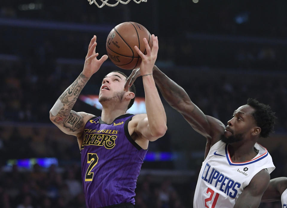 Los Angeles Lakers guard Lonzo Ball, left, shoots as Los Angeles Clippers guard Patrick Beverley defends during the first half of an NBA basketball game Friday, Dec. 28, 2018, in Los Angeles. (AP Photo/Mark J. Terrill)