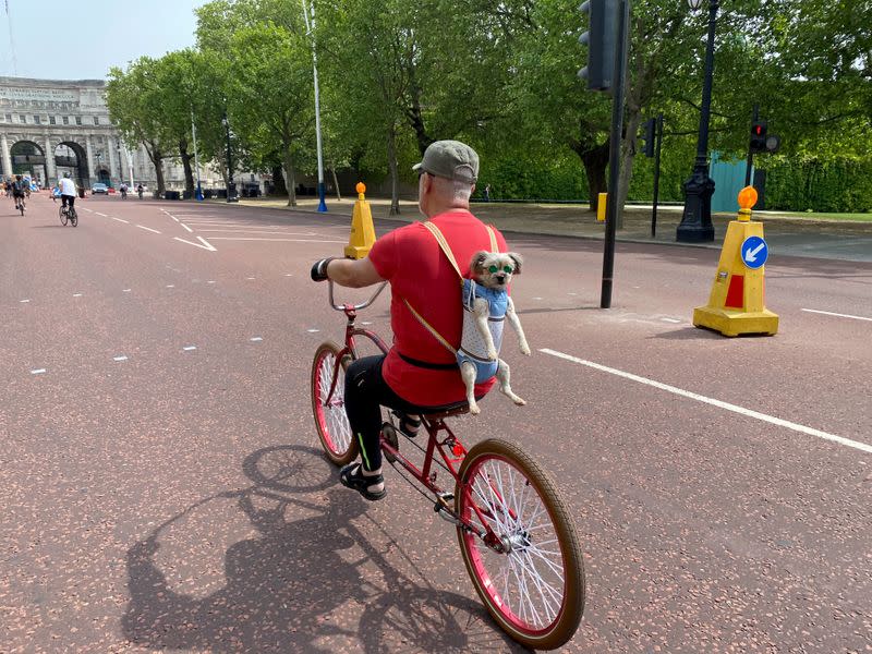 FILE PHOTO: A man takes advantage of London's empty streets to take his dog for a spin as the coronavirus lockdown continues