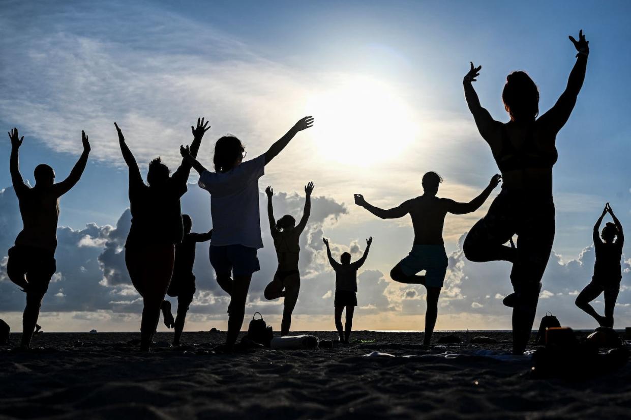 Celebrating International Yoga Day on the beach in Miami Beach, Fla., in 2022. <a href="https://www.gettyimages.co.uk/detail/news-photo/group-of-people-participate-in-a-yoga-session-to-mark-news-photo/1241436589?adppopup=true" rel="nofollow noopener" target="_blank" data-ylk="slk:Chandan Khanna/AFP via Getty Images;elm:context_link;itc:0;sec:content-canvas" class="link ">Chandan Khanna/AFP via Getty Images</a>