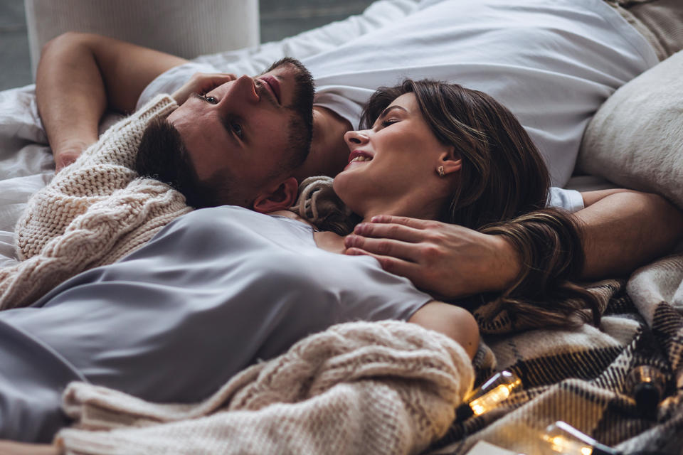 Loving young smiling couple relaxing in bed