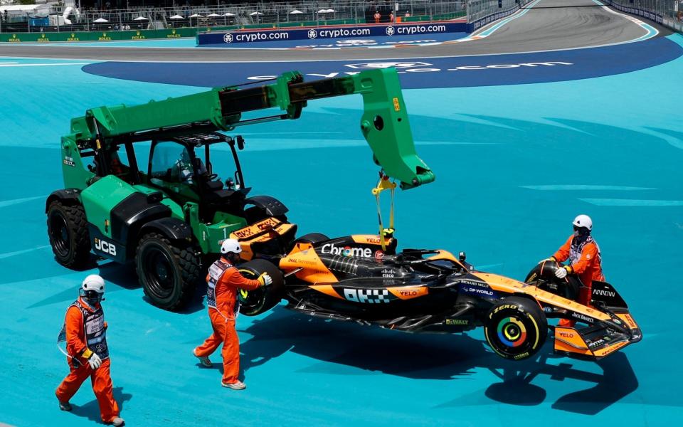 Stewards retrieve the car of McLaren's Lando Norris during the sprint race in Miami