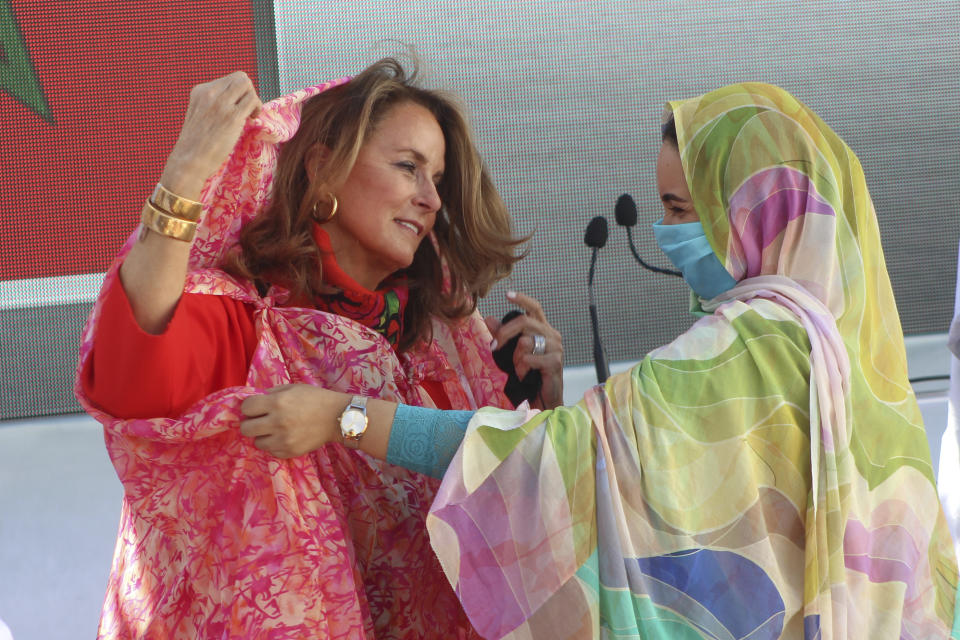 The wife of US Ambassador to Morocco, Jennifer Fischer, is presented a Sahraoui traditional wear after arriving in Dakhla, Morocco-administered Western Sahara, Sunday Jan. 10, 2021. The highest ranking U.S. diplomat for North Africa and the Middle East, as well as the first ever U.S Ambassador, traveled Sunday to the Morocco-administered Western Sahara city of Dakhla, laying the groundwork for the United States to set up a consulate in the disputed territory. (AP Photo/Noureddine Abakchou)