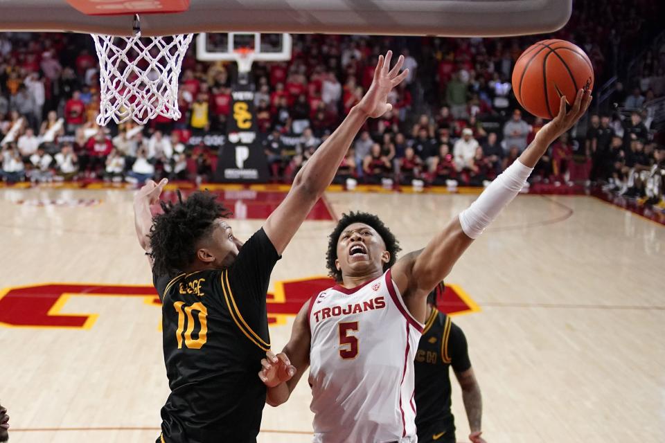 Southern California guard Boogie Ellis, right, shoots as Long Beach State guard AJ George defends during the second half of an NCAA college basketball game Sunday, Dec. 10, 2023, in Los Angeles. | Mark J. Terrill, Associated Press