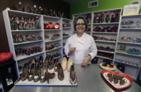 In this Feb. 7, 2013 photo, master chocolatier Andrea Pedraza shows off her chocolate shoes and other treats at her shop in the Oak Cliff section of Dallas. Florists and chocolate makers are working around the clock for the busy season - Valentine's Day. Pedraza's most well known creations are chocolate pumps done in the style of Christian Louboutin shoes. (AP Photo/LM Otero)