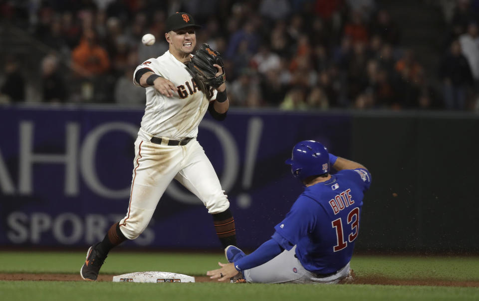 San Francisco Giants second baseman Joe Panik, left, throws to first base after forcing Chicago Cubs' David Bote (13) at second base on a double play hit by Addison Russell during the ninth inning of a baseball game in San Francisco, Tuesday, July 23, 2019. (AP Photo/Jeff Chiu)