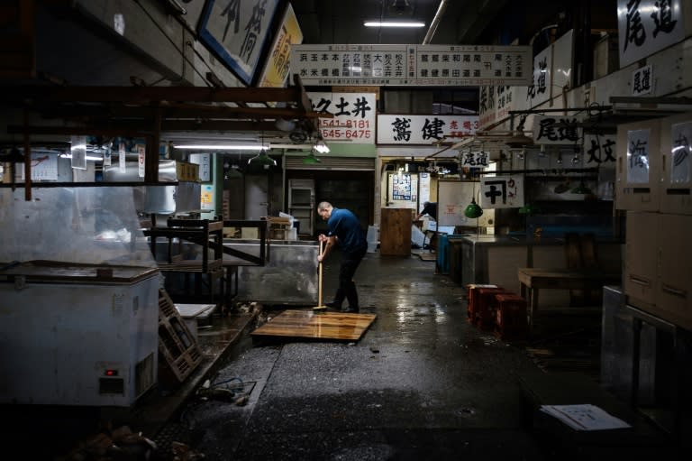 A fishmonger cleans his shop at the Tsukiji fish market one last time