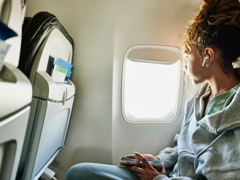 Girl looking out of the window on airplane.