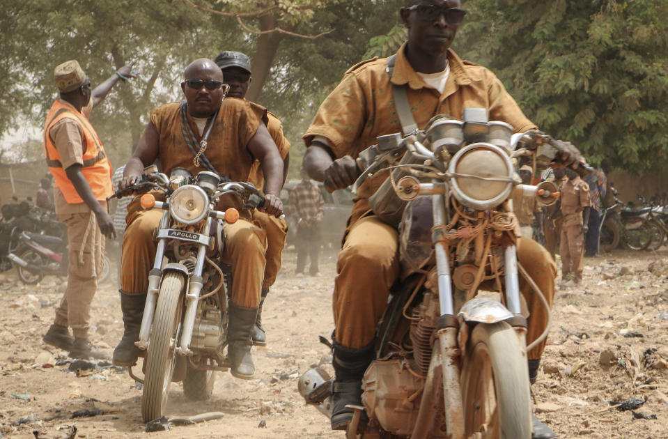 A group of local defense force fighters drive their motorbikes during an event to inaugurate a new chapter of the group in Ouagadougou, Burkina Faso, Saturday, March 14, 2020. In an effort to combat rising jihadist violence, Burkina Faso’s military has recruited volunteers to help it fight militants. (AP Photo/Sam Mednick)